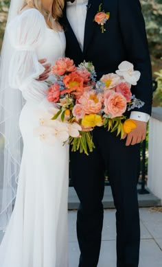 the bride and groom are posing for a photo with flowers in their bouquets on their wedding day