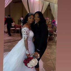 two women in wedding dresses posing for the camera