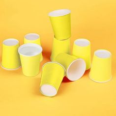 several yellow cups sitting on top of each other in front of a yellow background,