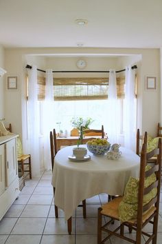 a dining room table with chairs and a bowl of flowers on top of the table