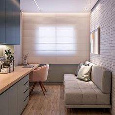 a living room with a couch, desk and chair next to a wall that has white bricks on it