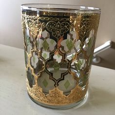 a gold and green glass on a table