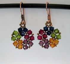 two pairs of colorful earrings hanging from a hook