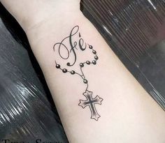 a cross tattoo on the wrist that says,'free'and is decorated with beads