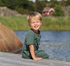 a little boy that is sitting on a dock