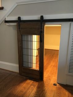 an empty room with a sliding door and hard wood flooring