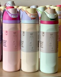 several different colored water bottles lined up on a shelf