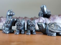 three metal figurines sitting on top of a wooden table next to each other