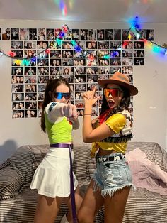 two young women are posing for the camera in front of a wall with pictures on it