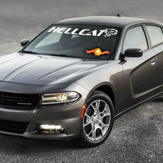 a gray dodge charger parked in a parking lot with the word hemm on it's windshield