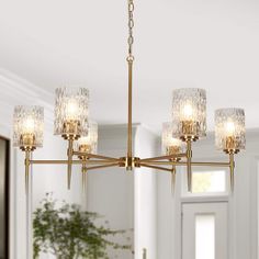 a chandelier hanging from the ceiling in a room with white walls and windows