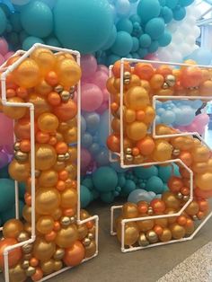 the number twenty five made out of balloons in gold, orange and teal colors