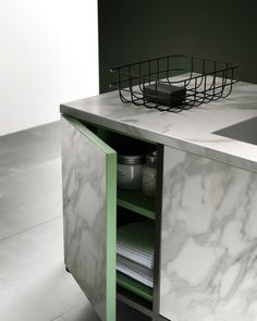 a white marble counter top sitting next to a sink in a room with green walls