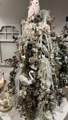 an artificial christmas tree is decorated with birds and snowflakes on it's branches