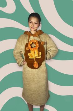 a woman in a lion costume holding a stuffed animal