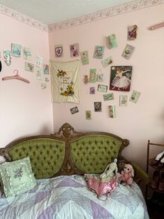 a bedroom with pink walls and lots of pictures on the wall above the headboard