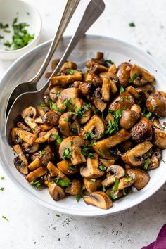 a white bowl filled with mushrooms and parsley