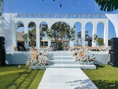 an outdoor ceremony setup with white flowers and greenery