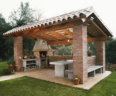 an outdoor kitchen and grill area in a backyard