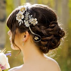 a woman holding a bouquet of flowers in her hand and looking at the back of her head