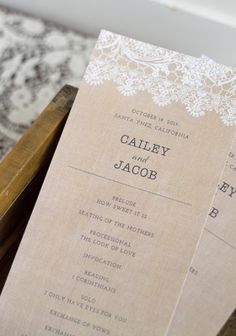 two wedding programs sitting on top of a wooden box