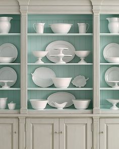 a white china cabinet with dishes on it