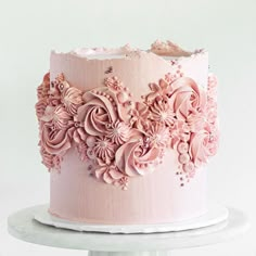 a pink frosted cake with flowers on it