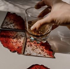 a hand is picking up some food from a glass on a tray with other items