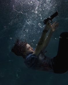 a man in the water with a camera attached to his arm and holding something up