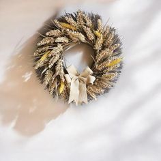 a dried wreath is sitting on a white sheet