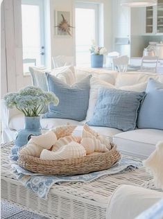 a living room filled with white furniture and blue pillows