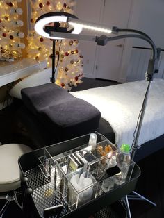 a vanity table with makeup and toiletries on it next to a bed in a bedroom