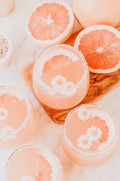 three glasses filled with grapefruit margaritas sitting on top of a marble counter