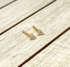 "Small, simple, everyday little triangle stud earrings. They have three tiny clear cubic zirconia round stones and measure about 0.1\" ( 2.8 mm ) and come with their own posts.  These studs are made of 18 K gold plated on 925 sterling silver with tiny cubic zirconia stones. They are the perfect earrings for people with sensitivities to certain metals. PLEASE NOTE - These studs are sold individually or as a pair. FREE Shipping for additional items  ~ All items are beautifully packed ready to give as a gift and carefully wrapped up to ensure a safe delivery. ~ The environment is very important for us therefore, in order to reduce waste, we will pack multiple items in one single package. If one of the pieces is intended as a gift, please leave a note at checkout and we'll be happy to pack it Second Hole Piercing, Piercing Cartilage, Triangle Earrings Stud, Studs Men, Triangle Studs, Studs Earrings, Men Jewelry, Earrings Minimalist, Reduce Waste