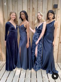 three women in dresses standing next to each other on a wooden floor with wood planks