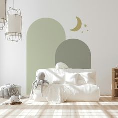 a white bed sitting in a bedroom next to a wall with a crescent on it