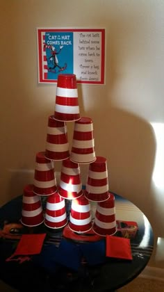 a stack of red and white striped cones sitting on top of a black round table