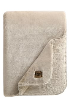 a white blanket with a brown tag on the front and back of it's pocket