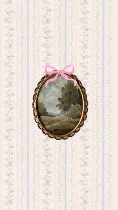 a painting with a pink bow hanging from it's side in front of a striped wallpaper