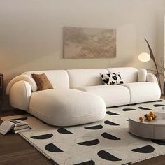 a living room with a white couch and black and white rugs on the floor