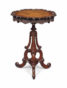 an ornately carved wooden table on stand