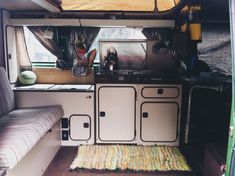 the interior of a camper with an oven, sink and stove top in it