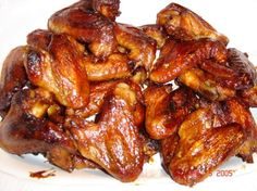 a white bowl filled with meat on top of a checkered tablecloth covered table