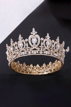 a gold tiara on a black surface