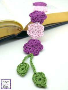 an open book with crocheted flowers on it