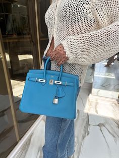 This Hermes Birkin 25 is a vision of elegance, embodying a serene yet captivating allure reminiscent of the northern skies. From 2019, this bag is fashioned from supple Swift leather, renowned for its smooth finish and ability to absorb dyes to the fullest, presenting a depth of color that is both rich and vibrant. The Bleu du Nord hue is a tranquil shade that offers a refreshing pop of color while maintaining an air of sophistication. Paired with the contemporary palladium hardware, the bag ref Luxury Blue Bag, Blue Hermes Bag, Blue Birkin Bag, Hermes Birkin Colours, Hermes Birkin Bag 25, Hermes Birkin Blue, Birkin Blue, Blue Birkin, Hermes Birkin 40