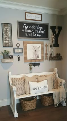 a white bench with some pillows and pictures on the wall