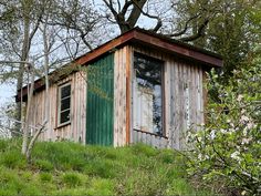 an outhouse sitting on top of a lush green hillside