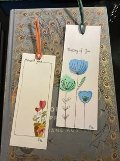 two tags with flowers on them are attached to a book