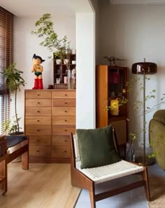 a living room filled with lots of furniture and plants on top of wooden dressers